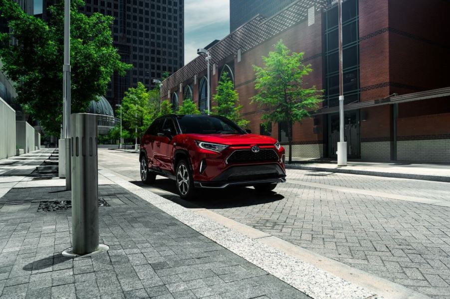 A 2023 Toyota RAV4 Prime XSE plug-in hybrid compact SUV model parked on a cobblestone road under streetlights