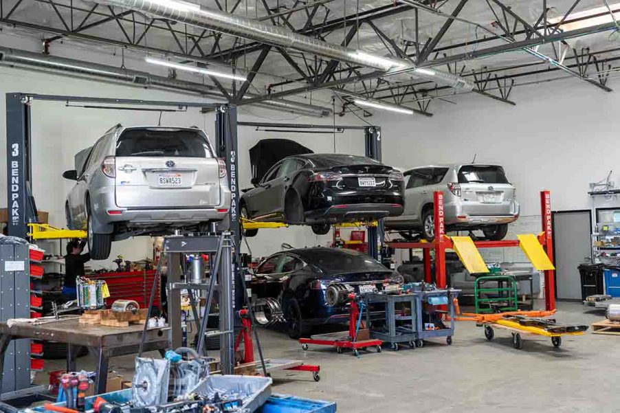 Toyota RAV4 EV and Tesla Model S on Lift inside Electric Car Repair Shop