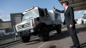 Daimler AG's Wolfgan Bernhard waving to a passing Mercedes-Benz Unimog model in Stuttgart, Germany