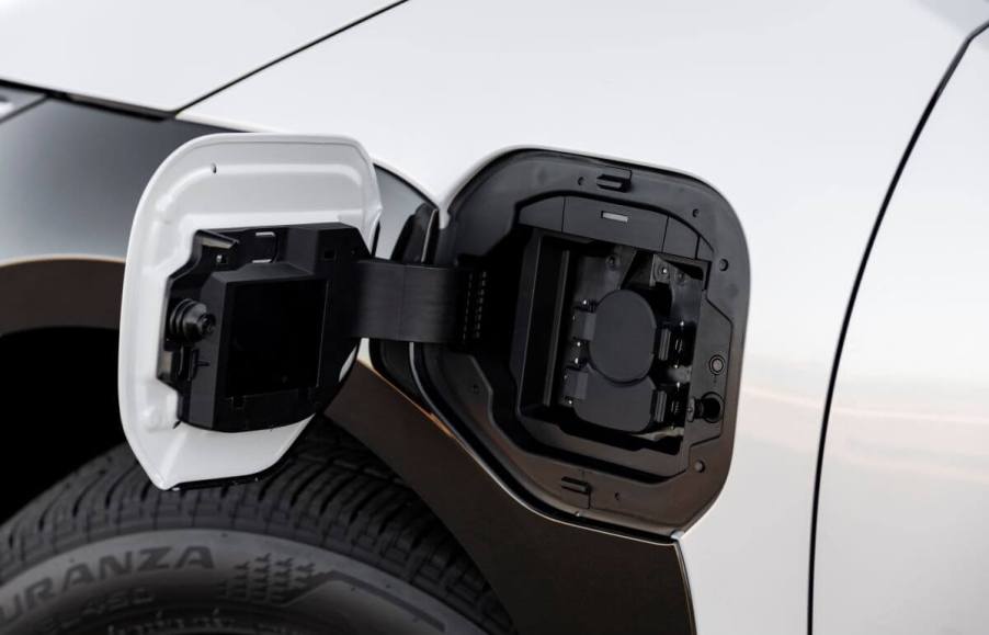 An open charging port on a white 2023 Toyota bZ4X electric compact SUV model