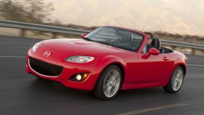 bright red NC Mazda Miata driving down the road