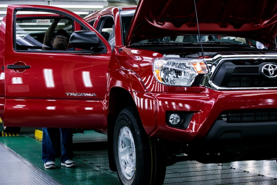 A worker checks over a used Toyota Tacoma in the final production line before driving the truck out of the factory at the Toyota Motor Manufacturing Texas