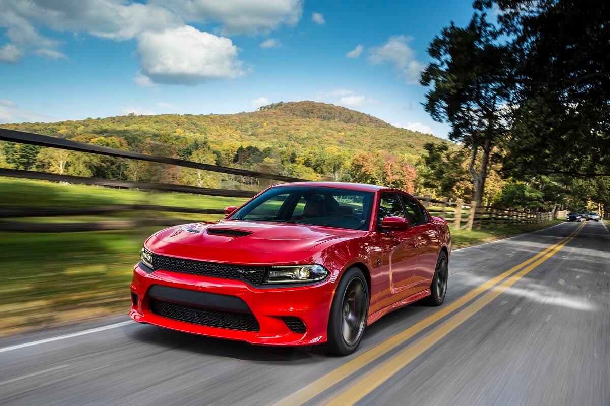 A red 2015 Dodge Charger SRT Hellcat drives on back roads. 