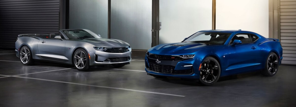 A pair of Chevrolet Camaro models park inside.