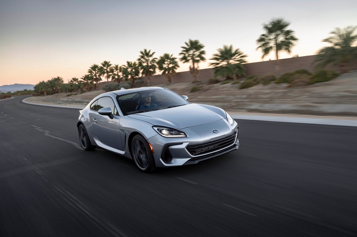 A silver 2022 Subaru BRZ blasts down a coastal road.