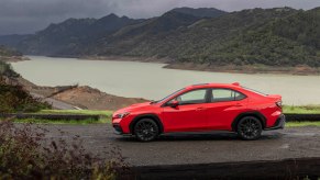 A red 2022 Subaru WRX parked in front of a lake. The Subaru WRX price is higher than it should be to be competitive in sales.