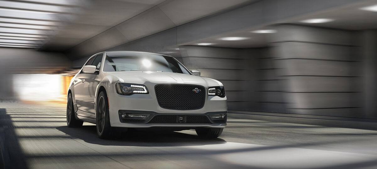 A white 2023 Chrysler 300C drives through a tunnel. 