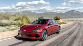 Red 2023 Hyundai Ioniq 6 owner speeding down a desert road.