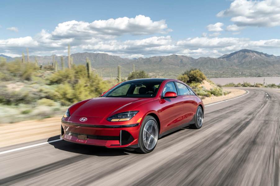 Red 2023 Hyundai Ioniq 6 owner speeding down a desert road.