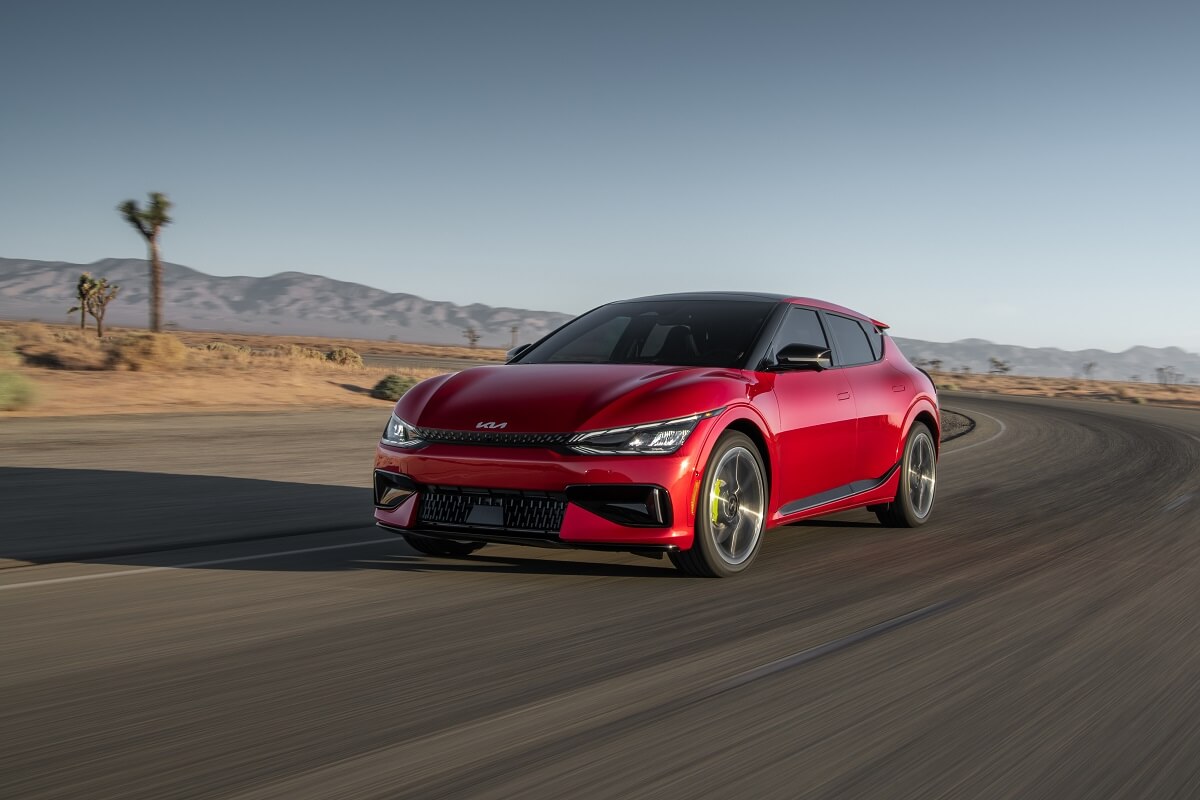 A red 2023 Kia EV6 GT blasts around a corner.