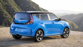 A blue 2023 Kia Soul subcompact SUV is parked off-road.