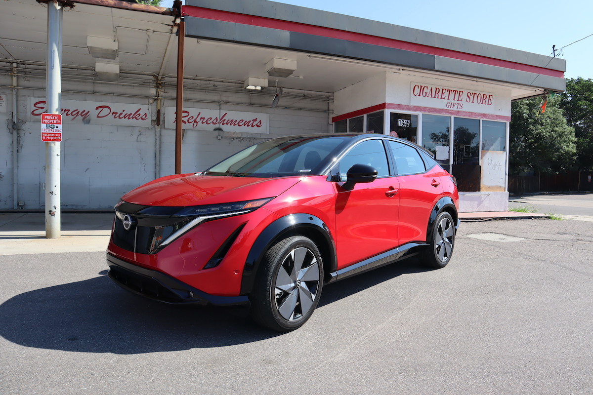 A front left corner view of the 2023 Nissan Ariya at a gas station.