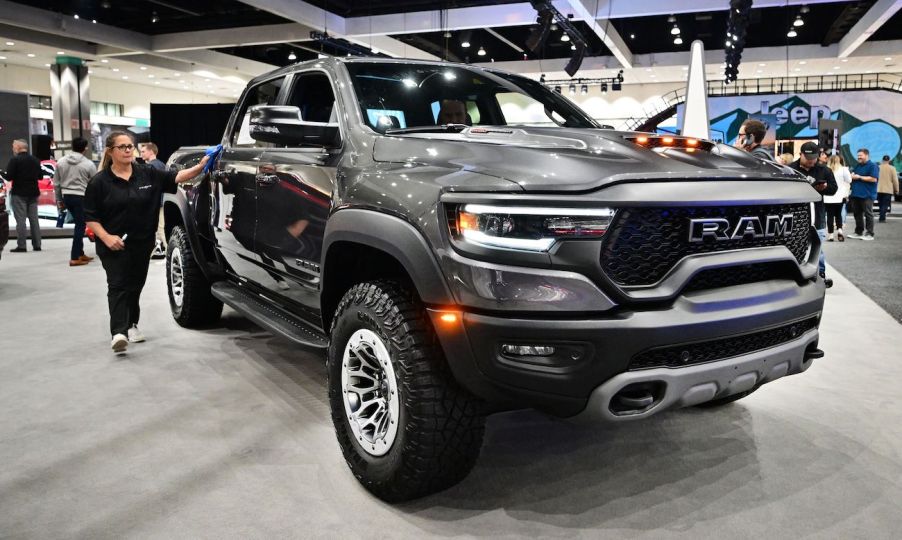 A woman cleans the side of the 2023 Ram 1500 TRX trim level on display at the 2022 Los Angeles Auto Show