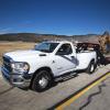 A Ram 3500 Heavy Duty Tradesman regular cab pickup truck model towing a construction crane down a highway