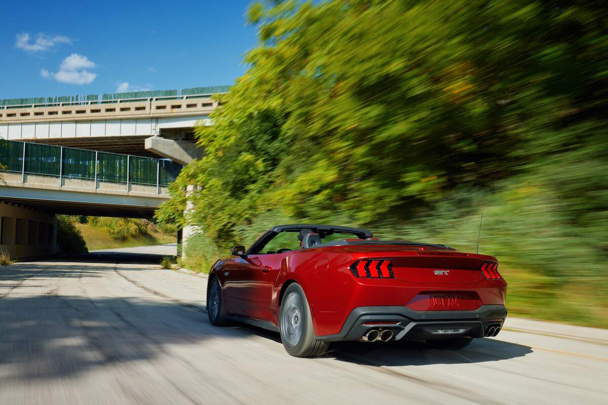 A red 2024 Ford Mustang convertible with the top down on a sunny day