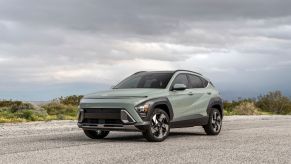 A green 2024 Hyundai Kona parked on a cloudy day. The Hyundai Kona sales beat out the Kia Seltos so far this year