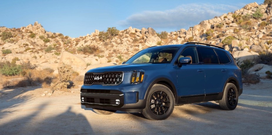 A blue 2024 Kia Telluride midsize three-row SUV is parked outdoors. 