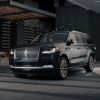 A dark black 2024 Lincoln Navigator full-size luxury SUV model demonstrating its illumination sequence