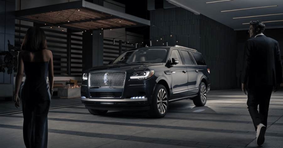 A dark black 2024 Lincoln Navigator full-size luxury SUV model demonstrating its illumination sequence