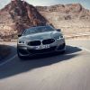 A gray BMW 8 Series M850i xDrive Convertible model turning along a stretch of desert highway