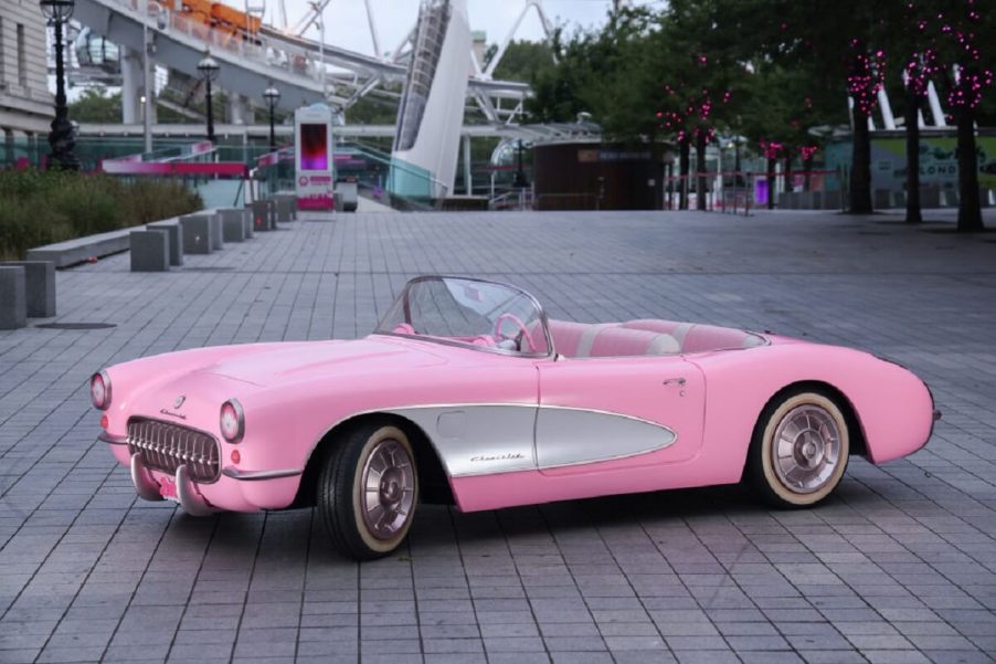 A pink 1956 Chevrolet Corvette C1 from the film "Barbie," parks next to the London Eye.