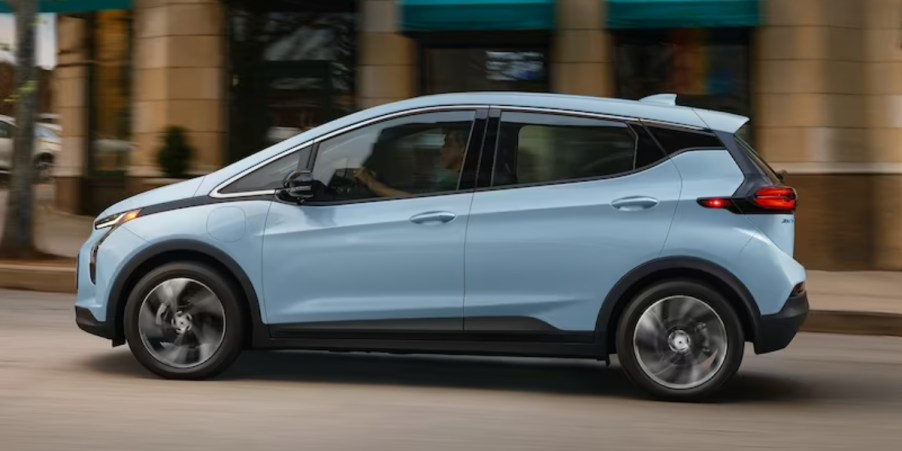 A blue 2023 Chevrolet Bolt EV is driving on the road.