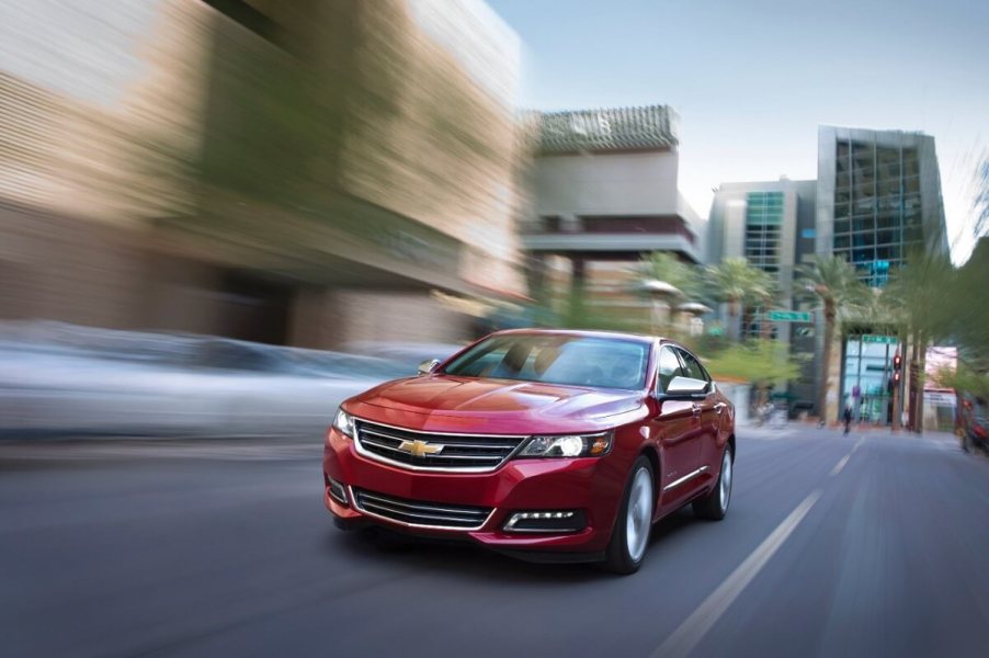 A red Chevrolet Impala blasts down a city street.