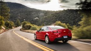 A bright-red Chevrolet SS cruises down back roads.