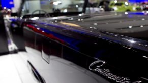 A dark blue Lincoln Continental Convertible shows off its badge.