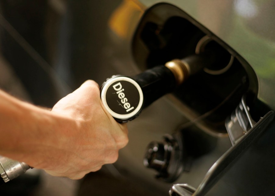 Car or pickup truck driver fueling up with a diesel nozzle.