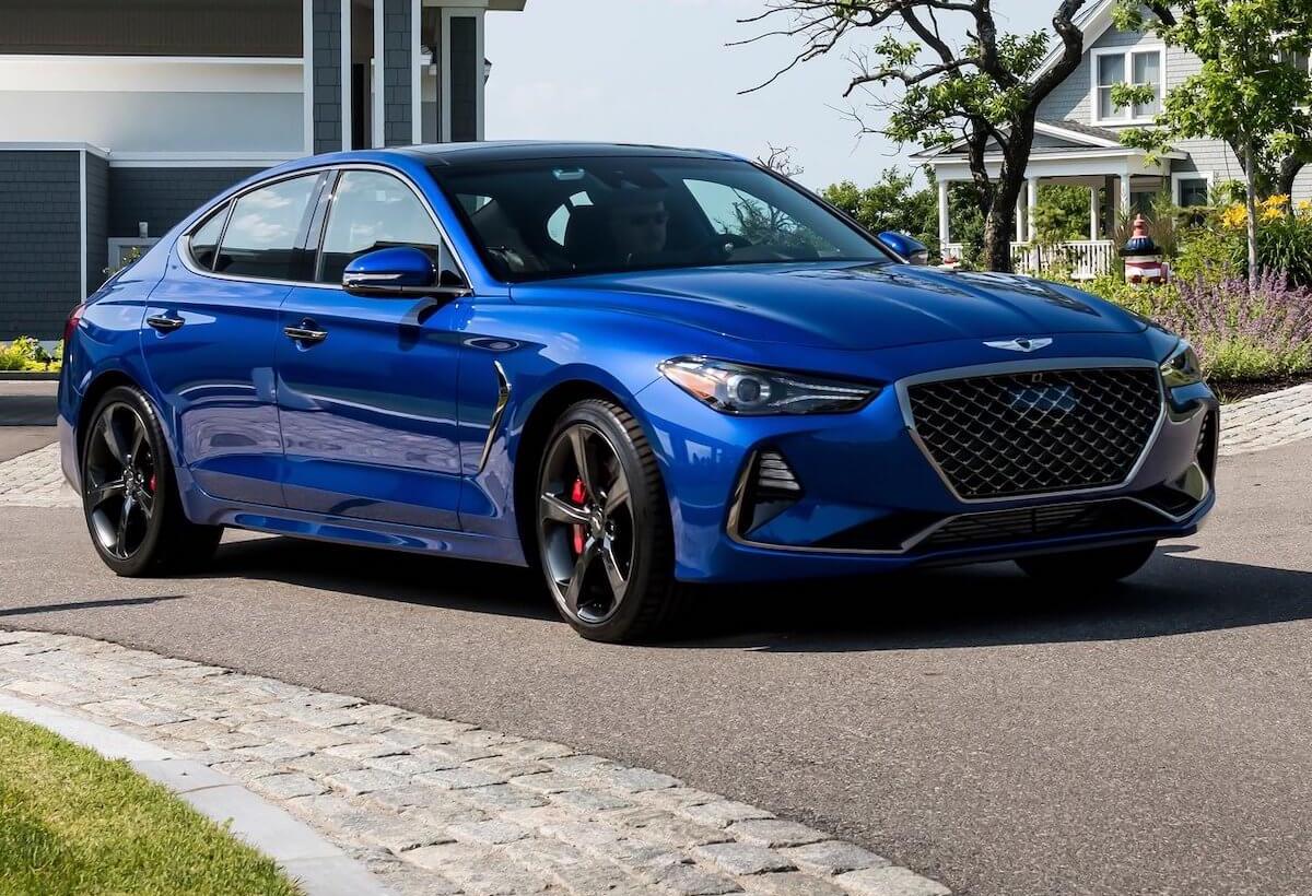 A 2021 Genesis G70 in blue parked in front of a house