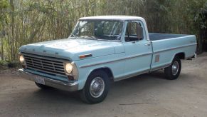 A blue 1968 F-100 truck parked on cement