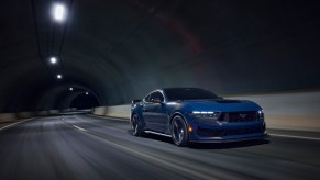 A Blue Ember Metallic 2024 Ford Mustang Dark Horse drives through a tunnel.