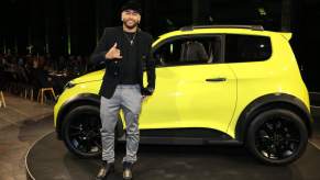 Soccer player Neymar stands next to an e.wave X electric car by e.GO