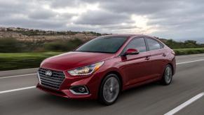 A red Hyundai Accent on an open highway.