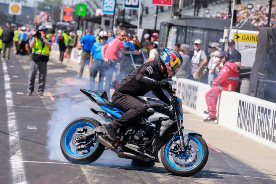 A person doing a burnout riding a street bike.