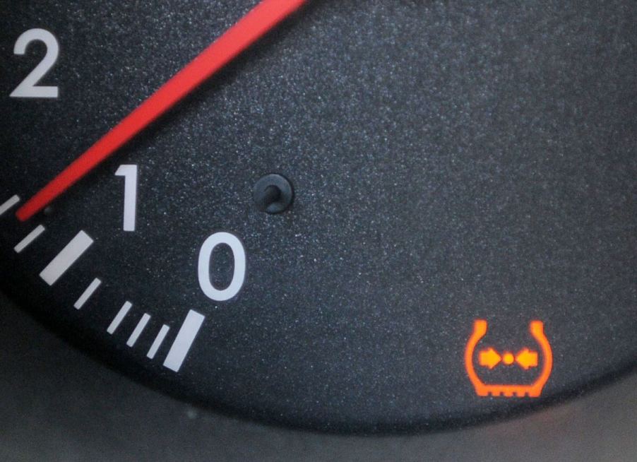 The dashboard of a Lexus luxury vehicle illuminated with a Tire Pressure Monitoring System (TPMS) warning light