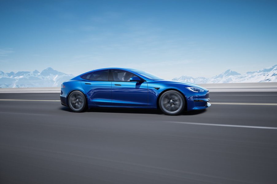 A blue Tesla Model S drives down the street