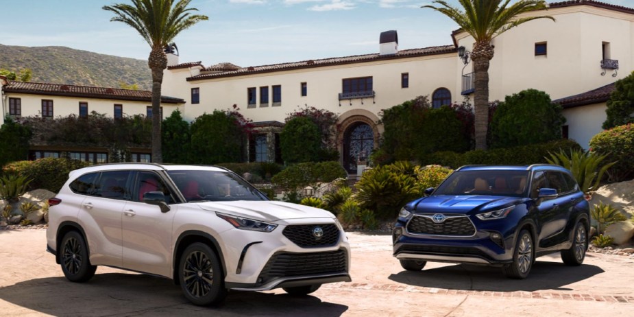 A white Toyota Highlander (L) and a blue Toyota Highlander (R) are parked. 