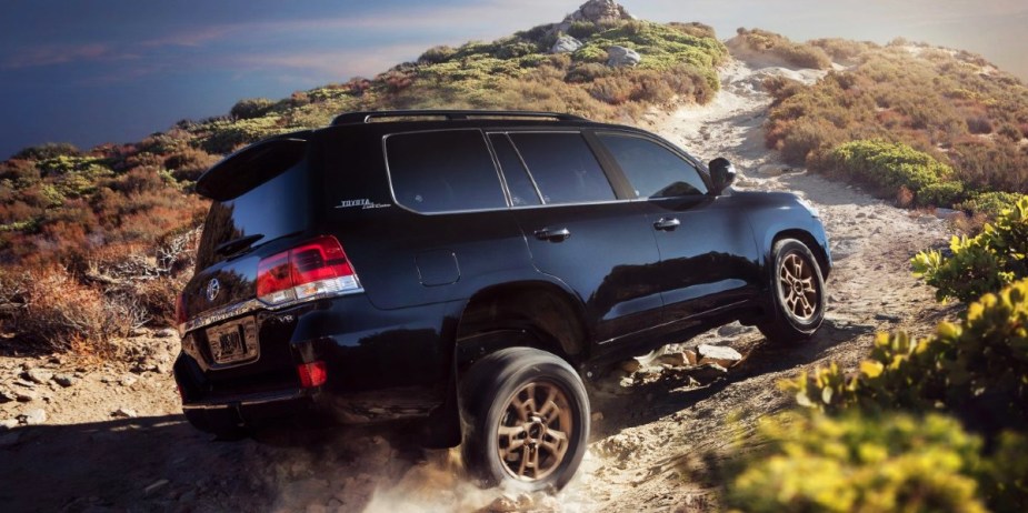 A blue 2021 Toyota Land Cruiser full-size SUV is driving off-road. 