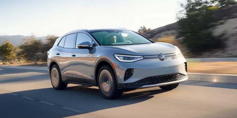 A gray 2023 Volkswagen ID.4 small electric SUV is driving on the road. 