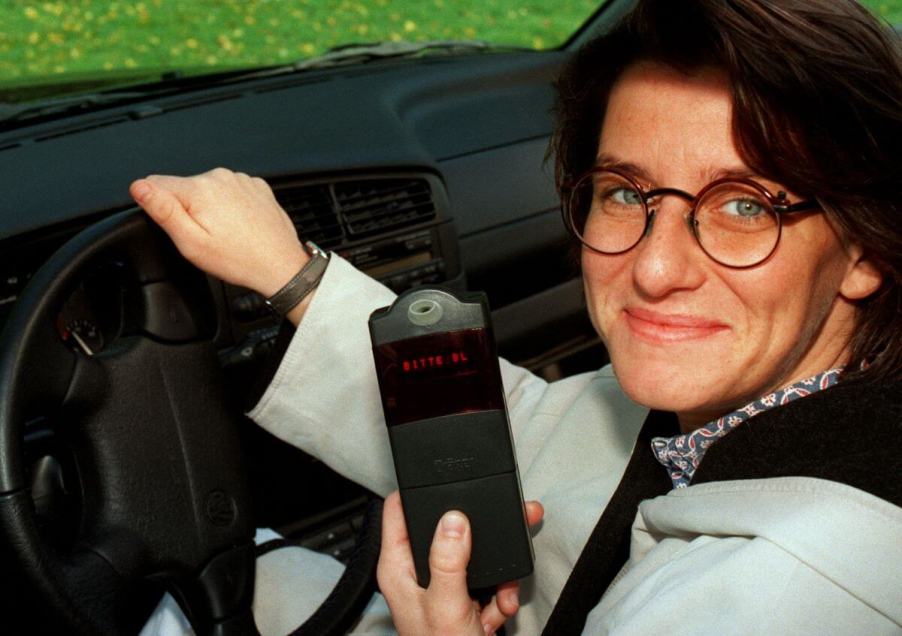 Touring car driver Ellen Lohr holding a car electronic immobilizer device at the International Trade Fair