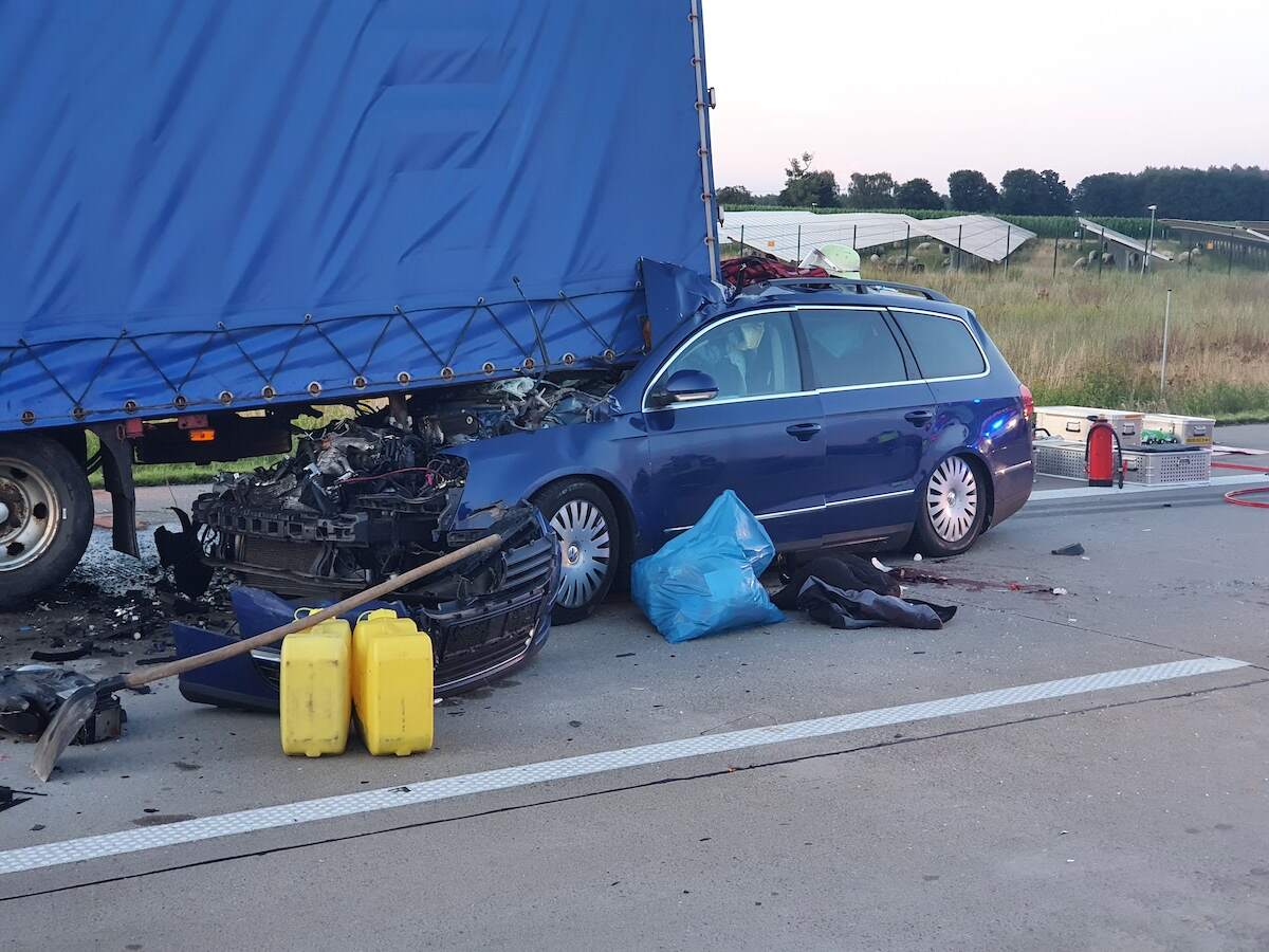 A car stuck under a truck trailer after a serious accident