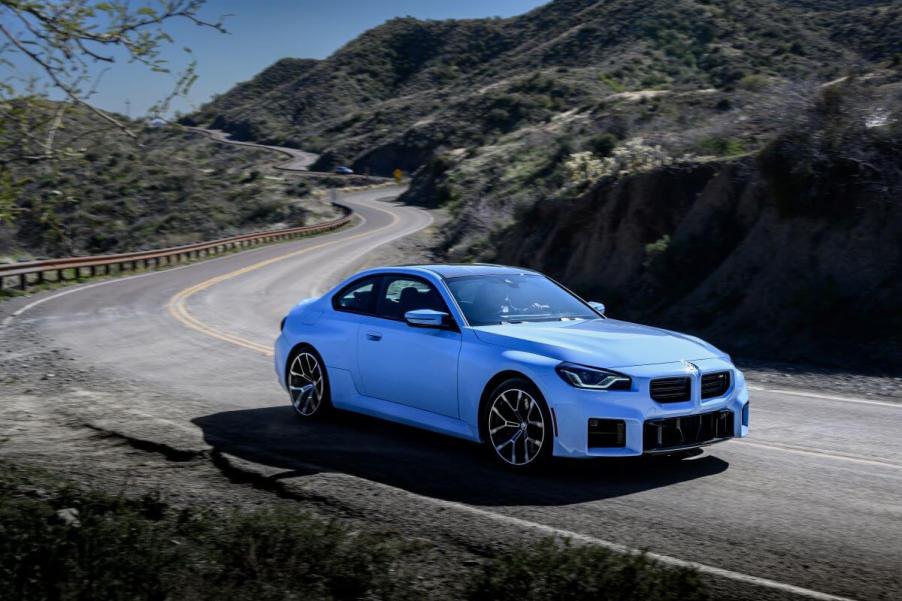 A BMW M2 subcompact executive car in Zandvoort Blue driving on a mountain highway