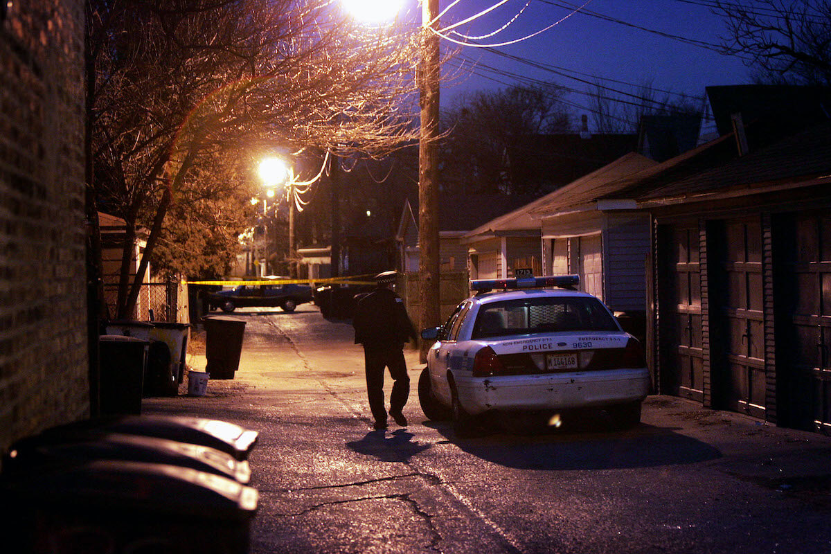 A police officer patrols a back alley way.