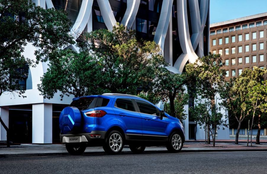 A rear shot of the trunk and spare tire on a blue 2021 Ford EcoSport subcompact SUV model parked in a city