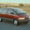 A 1991 Toyota Previa minivan model parked near dry and barren grass fields