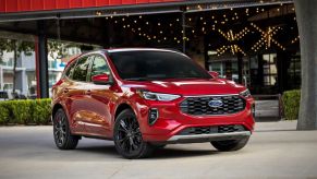 A 2023 Ford Escape ST-Line Elite compact crossover SUV model in Rapid Red parked on a concrete plaza