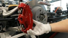 A red brake caliper and rotor for a Taycan electric sports car model in a Porsche AG factory in Stuttgart, Germany