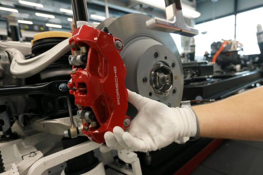 A red brake caliper and rotor for a Taycan electric sports car model in a Porsche AG factory in Stuttgart, Germany